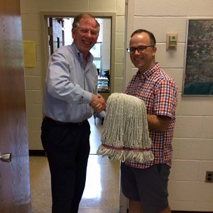 Outgoing Chair John McGlennon passes on the tools of power to his successor Paul Manna